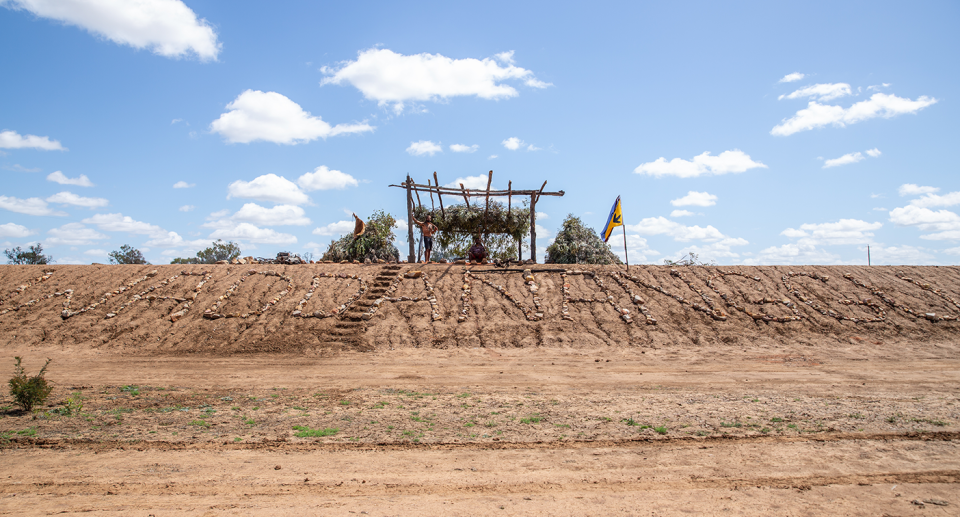 An image showing the Wangan and Jagalingou from a distance, on top of a mound.