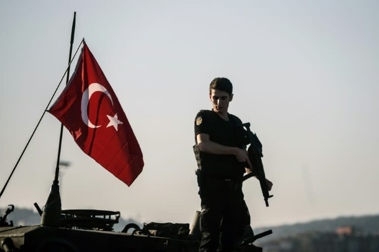 A Turkish police officer stands guard on a tank after the failed military coup that claimed the lives of 240 people on July 15