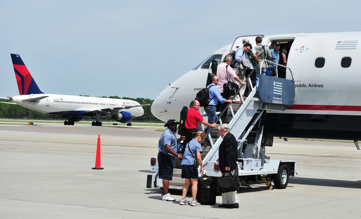 Passengers board a US Airways Express flight to Charlotte, N.C., as a Delta Boeing 757 taxis to the runway, at Augusta Regional Airport, in this photo from 2011. Delta is increasing its number of flights into and departing Augusta during the Masters Tournament.