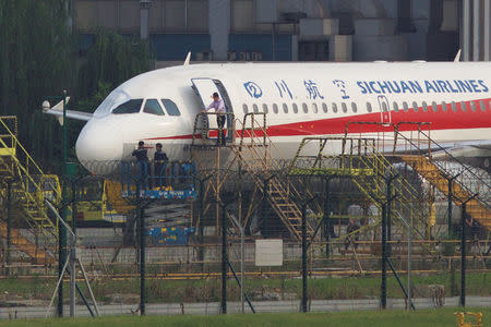 Workers inspect a Sichuan Airlines aircraft that made an emergency landing after a windshield on the cockpit broke off, at an airport in Chengdu, Sichuan province, China May 14, 2018. Picture taken May 14, 2018. REUTERS/Stringer