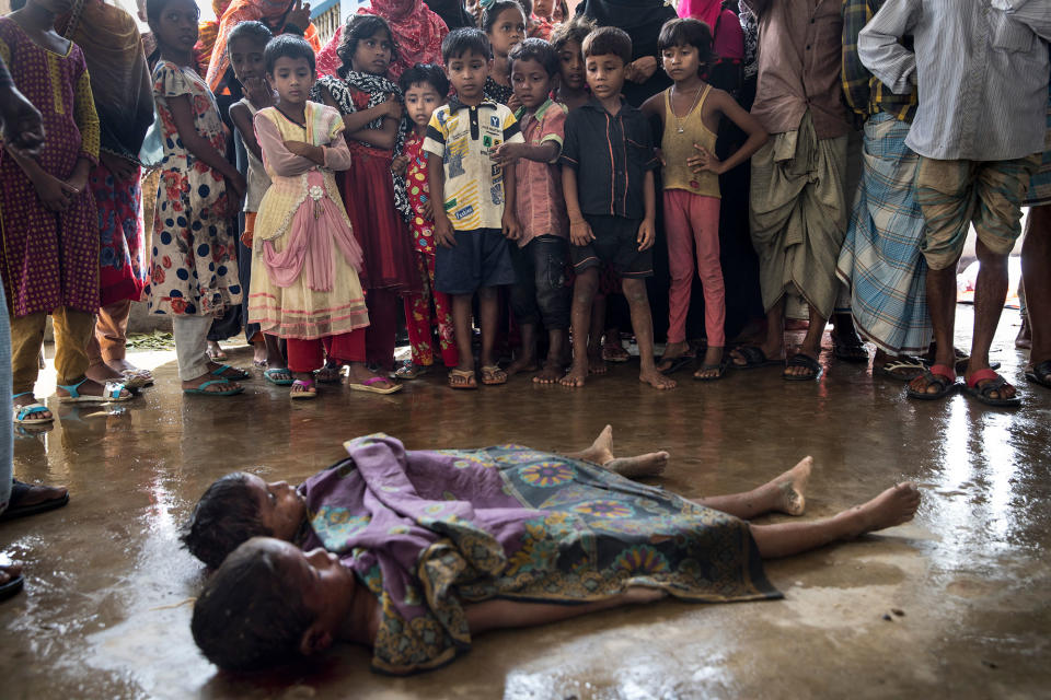 <p>SEPT. 29, 2017 – Children watch in Inani , Bangladesh, as the bodies of children are prepared for the funeral after a boat sunk in rough seas off the coast of Bangladesh carrying over 100 people . Seventeen survivors were found along with the bodies of 20 women and children with over 50 missing. Over a half a million Rohingya refugees have fled into Bangladesh from the horrific violence in Rakhine state in Myanmar causing a humanitarian crisis. (Photo: Paula Bronstein/Getty Images) </p>