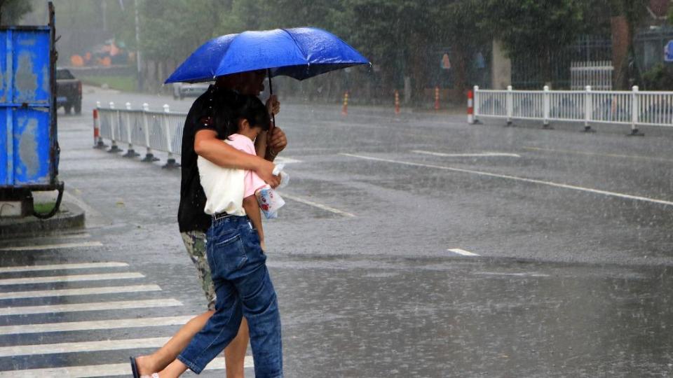 浙江台州居民在暴雨中行走。（圖／翻攝自《澎湃新聞》）