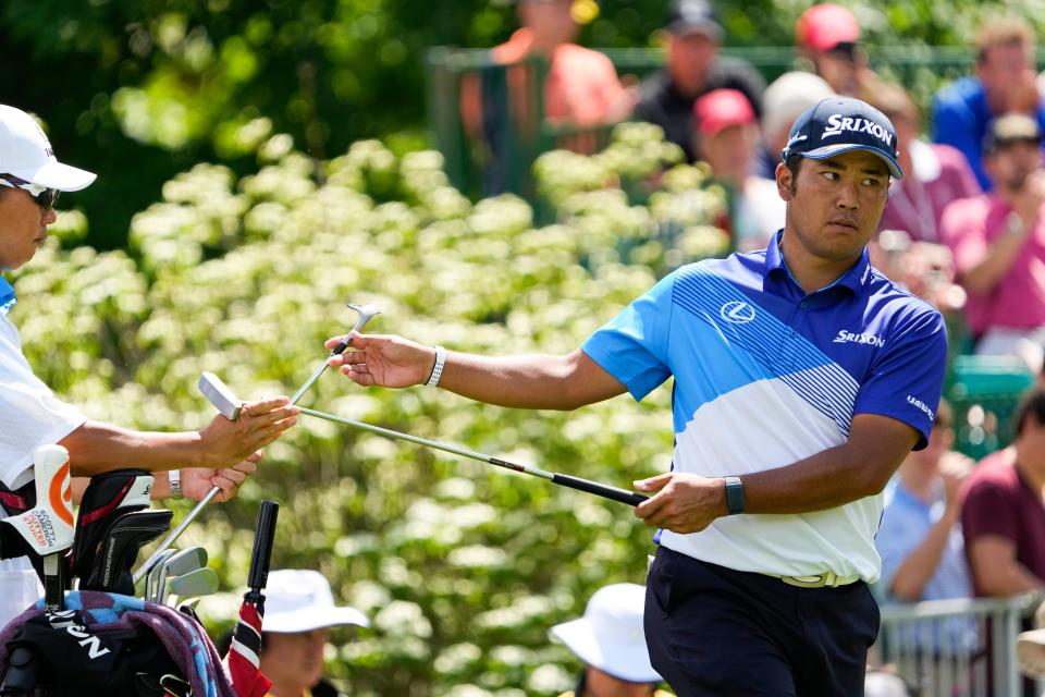 Jun 2, 2022; Dublin, Ohio, USA; Hideki Matsuyama trades clubs with his caddie on the 8th hole during the first round of the Memorial Tournament at Muirfield Village Golf Club on June 2, 2022. Mandatory Credit: Adam Cairns-The Columbus Dispatch