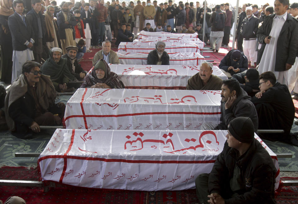 People from the Shiite Hazara community gather around caskets of coal mine workers who were killed by unknown gunmen near the Machh coal field, during a sit-in protest, in Quetta, Pakistan, Monday, Jan. 4, 2021. Gunmen opened fire on a group of minority Shiite Hazara coal miners after abducting them, killing 11 in southwestern Baluchistan province early Sunday, a Pakistani official said. (AP Photo/Arshad Butt)