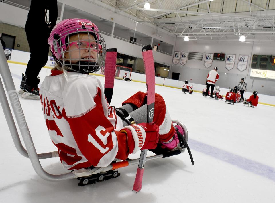 Callie Higdon-Hamilton, 7, of Monroe on the novice team Belle Tire Sled Hockey team looks up at the coach waiting her turn to play.