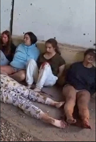 Female hostages who are Israeli soldiers Liri Albag, Agam Berger, Daniela Gilboa and Naama Levy sit on the ground during their capture by Gazan militants at Nahal Oz military base in southern Israel on October 7