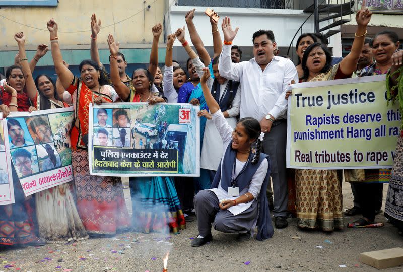 La gente grita consignas mientras celebran después de que la policía mató a tiros a cuatro hombres sospechosos de violar y matar a un veterinario de 27 años en Telangana, en Ahmedabad