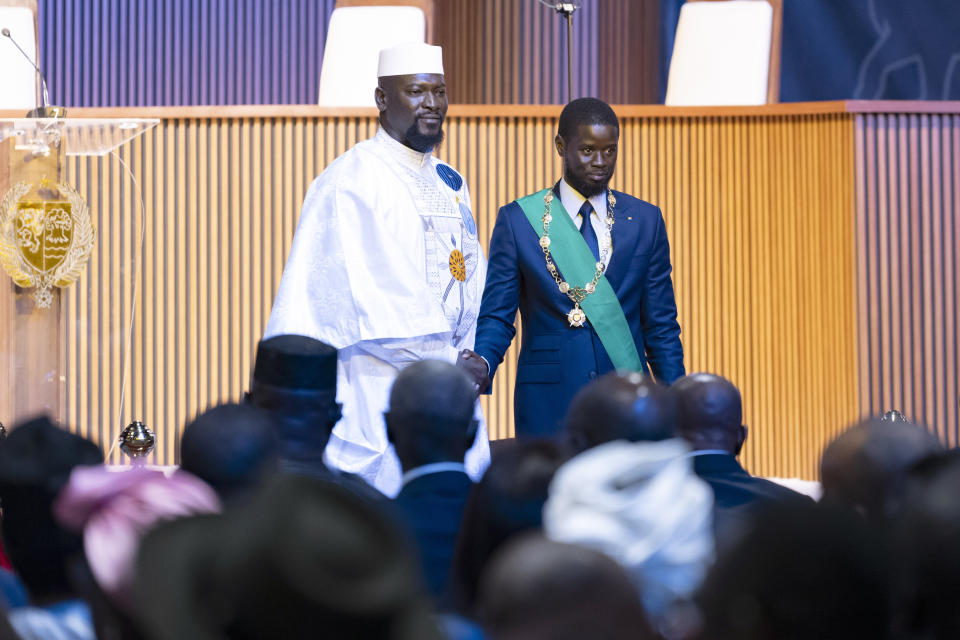 Bassirou Diomaye Faye, right, greets Guinea's interim president Mamadi Doumbouya during his swearing in ceremony as Senegal's president in Dakar, Senegal, Tuesday, April 2, 2024. Senegal has sworn in Bassirou Diomaye Faye as its new president, completing the previously little-known opposition figure’s dramatic ascent from prison to the palace in recent weeks. Faye was released from prison less than two weeks before the March election following a political amnesty announced by the outgoing president. (AP Photo/Sylvain Cherkaoui)