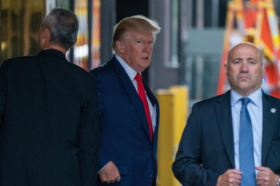 Former President Donald Trump looks warily at the photographer as he leaves the lobby of Trump Tower.