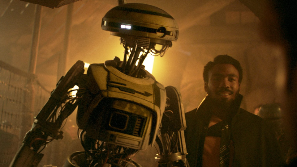 Droid L3-37 stands next to Lando Calrissian in Solo: A Star Wars Story.