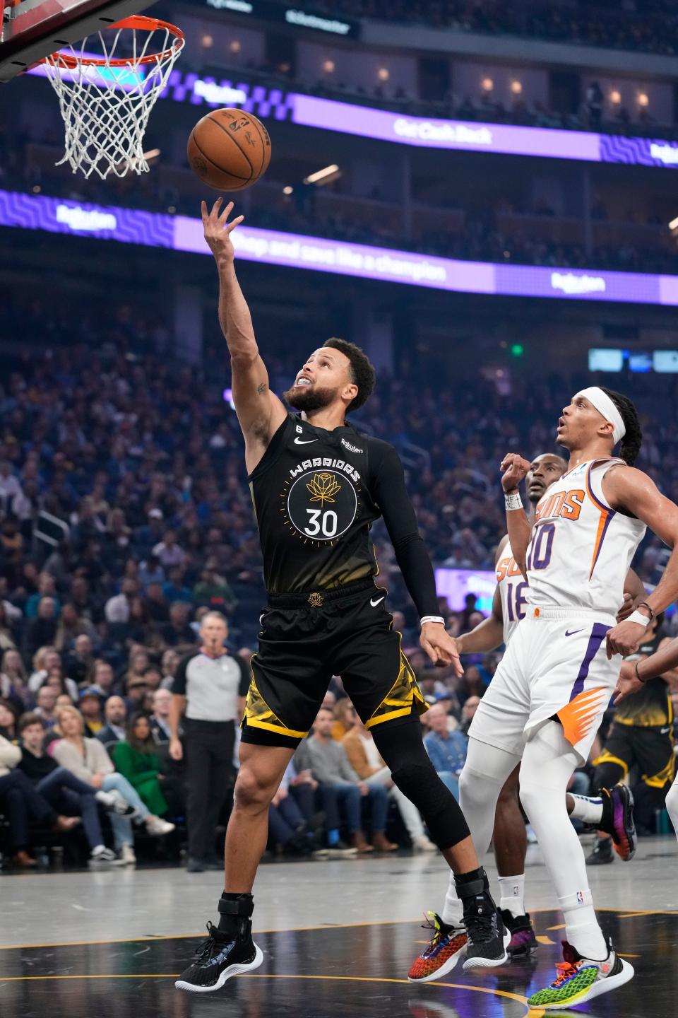 Golden State Warriors guard Stephen Curry (30) shoots next to Phoenix Suns' Damion Lee (10) during the first half of an NBA basketball game in San Francisco, Tuesday, Jan. 10, 2023. (AP Photo/Godofredo A. Vásquez)