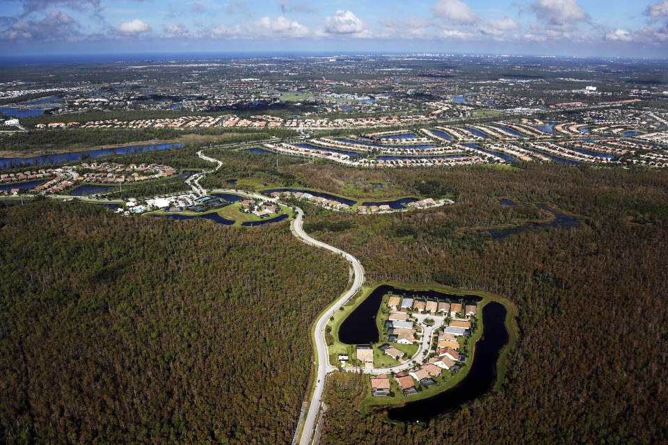 In this Thursday, Oct. 24, 2019, photo, a housing development built in Everglades wetlands is seen from the air near Naples, Florida. (AP Photo/Robert F. Bukaty)