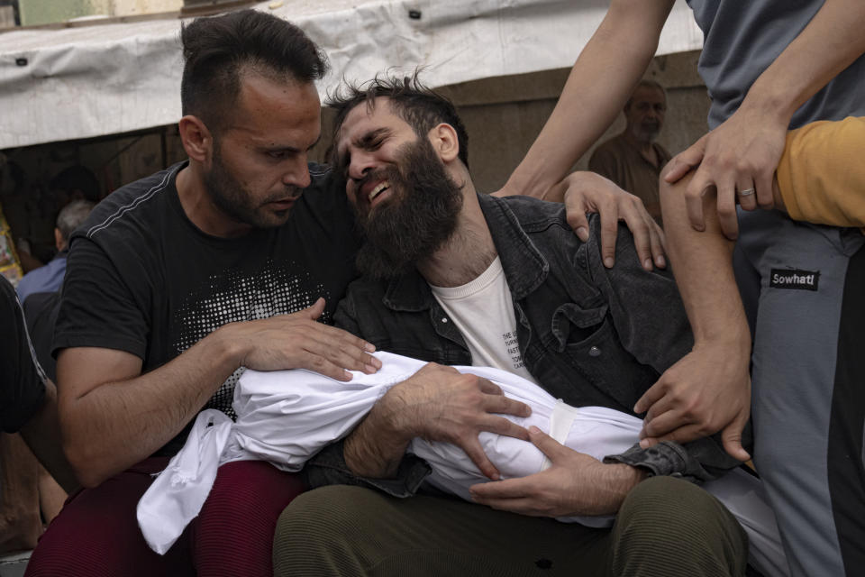 Palestinians mourn their relatives killed in the Israeli bombardment of the Gaza Strip, in a morgue in Khan Younis, Sunday, Oct. 29, 2023. ( AP Photo/Fatima Shbair)