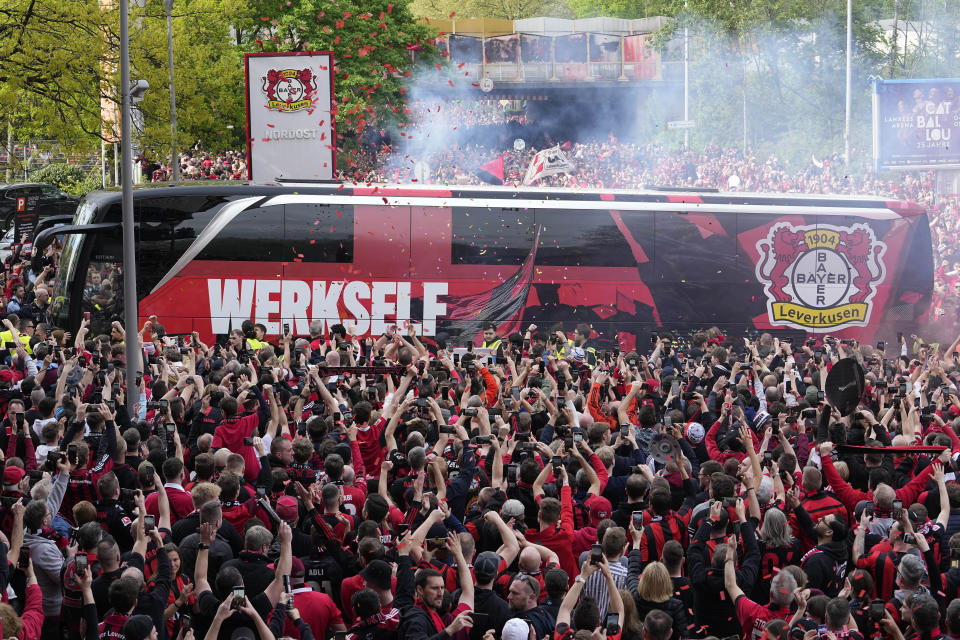 The team bus of Bayer Leverkusen is welcomed by thousands of supporters at the stadium ahead of the German Bundesliga soccer match between Bayer Leverkusen and Werder Bremen in Leverkusen, Germany, Sunday, April 14, 2024. Leverkusen could win the Bundesliga title if they win the match against Bremen.(AP Photo/Martin Meissner)