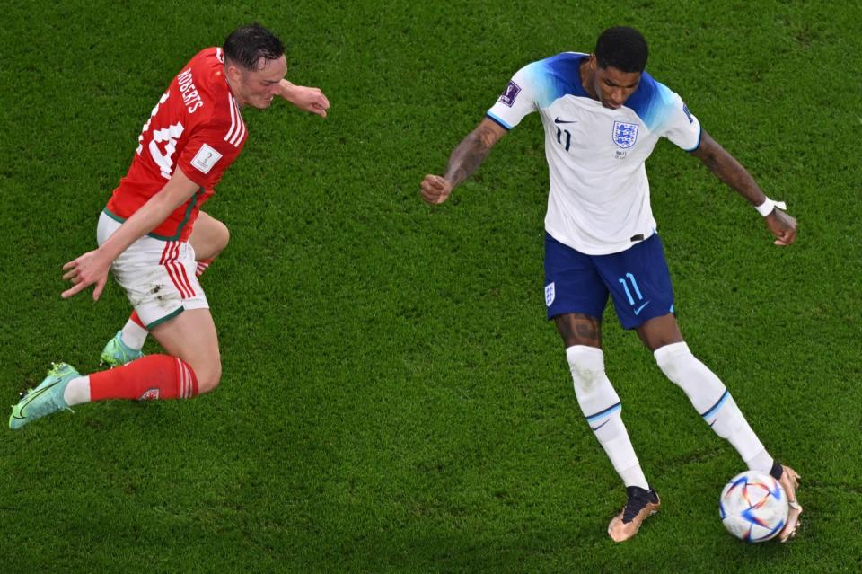 England's forward #11 Marcus Rashford (R) scores his team's third goal as Wales' defender #14 Connor Roberts (L) tries to defend during the Qatar 2022 World Cup Group B football match between Wales and England at the Ahmad Bin Ali Stadium in Al-Rayyan, west of Doha on November 29, 2022. (Photo by ANTONIN THUILLIER/AFP via Getty Images)