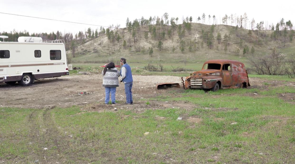 Pete and Dolly Andrew at the edge of their property in Aq'am in April 2024, looking over the land where their home once stood before it was destroyed by the St. Mary River wildfire in July 2023.  (Corey Bullock/CBC News - image credit)