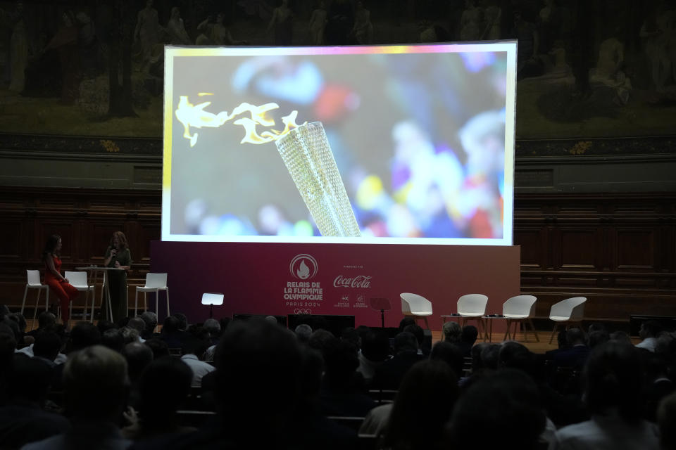 Guests wait for the start of a media conference for the unveiling of the route for the Paris 2024 Olympic Torch relay at Sorbonne University in Paris, Friday, June 23, 2023. The route of the Torch is expected to take in more than 60 departments across France as it is carried for three months in the lead-up to the July Olympics in Paris. (AP Photo/Christophe Ena)