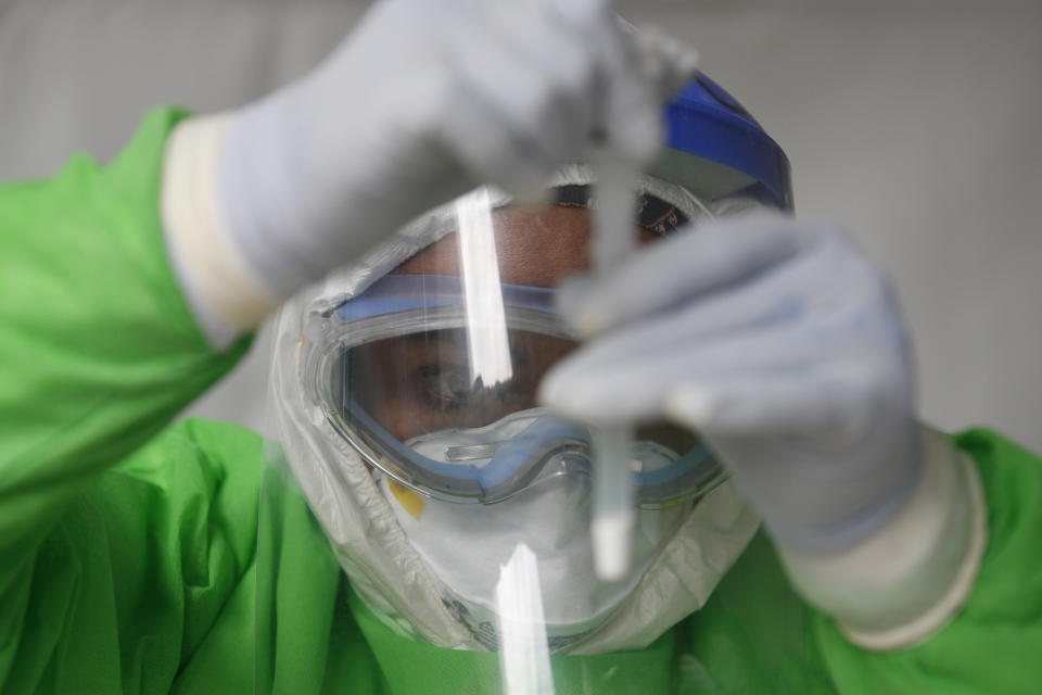 Nurse Cinthia Sanchez Gutierrez processes a rapid COVID-19 test immediately after collecting a nasal swab, in a tent set up to perform rapid coronavirus testing at the TAPO bus station in the Venustiano Carranza borough of Mexico City, Friday, Nov. 20, 2020. Mexico passed the 100,000 mark in confirmed COVID-19 deaths on Thursday, becoming only the fourth country to do so. (AP Photo/Rebecca Blackwell)