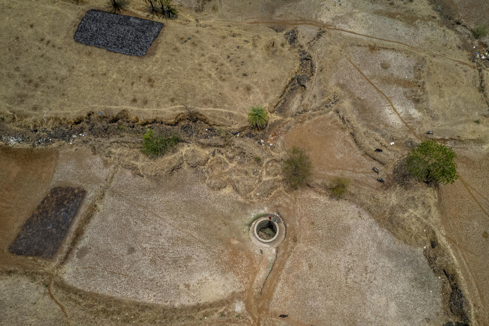 Women draw water from a well on a hot and humid day in the village of Telamwadi, northeast of Mumbai, India, Saturday, May 6, 2023. Rural areas in the country have been among the hardest hit with water shortages. (AP Photo/Dar Yasin)