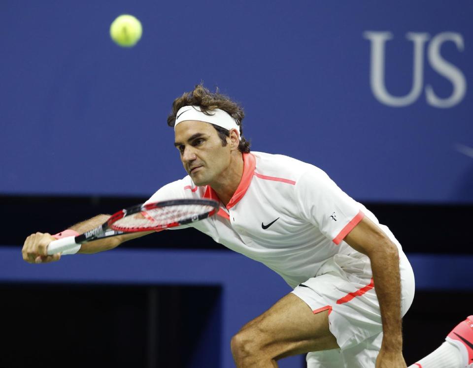 Roger Federer, of Switzerland, stretches out to return the ball during his fourth round match against John Isner at the U.S. Open tennis tournament in New York, Monday, Sept. 7, 2015. (AP Photo/Kathy Willens)