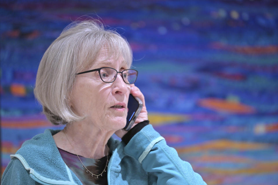 Claudia Goldin speaks to a reporter on the phone in her home in Cambridge, Mass. after learning that she received the Nobel Prize in Economics Monday, Oct. 9, 2023. Goldin, a professor at Harvard University, for advancing understanding of women's labor market outcomes. (AP Photo/Josh Reynolds)