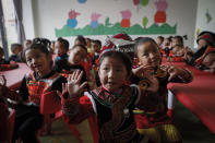 Ethnic minority children wearing their costumes learn to sing at a kindergarten class at the apartment houses compound built by the Chinese government in Yuexi county, southwest China's Sichuan province on Sept. 11, 2020. China's ruling Communist Party says its initiatives have helped to lift millions of people out of poverty. But they can require drastic changes, sometimes uprooting whole communities. They fuel complaints the party is trying to erase cultures as it prods minorities to embrace the language and lifestyle of the Han who make up more than 90% of China’s population. (AP Photo/Andy Wong)