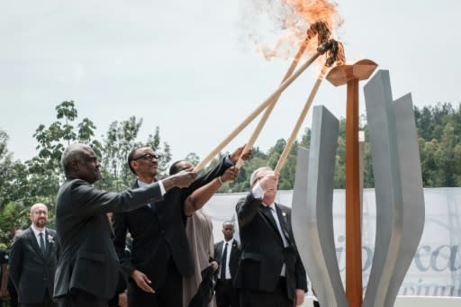 The Rwandan president, centre, lit the remembrance flame along with African Union chief Moussa Faki and Rwandan First Lady Jeannette Kagame