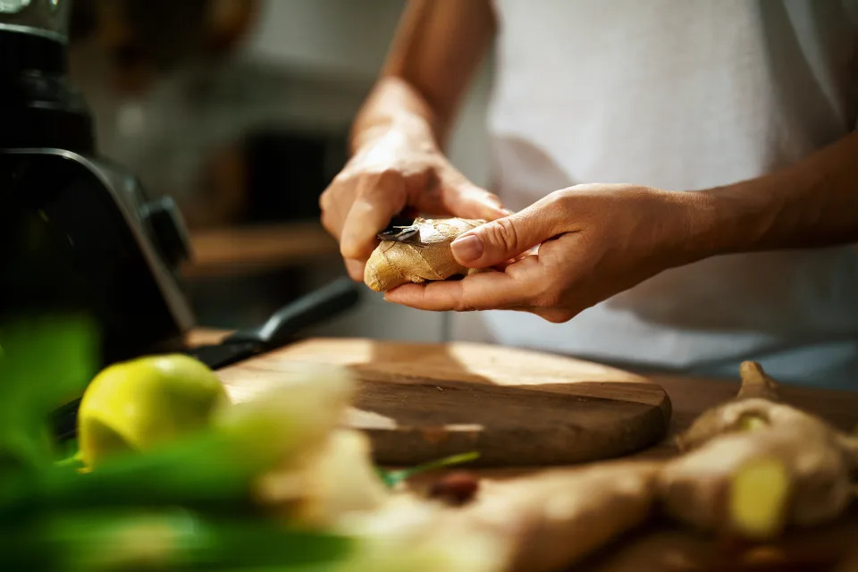 woman peeling a piece of ginger