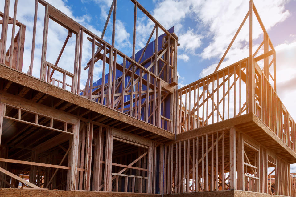 New house under construction framing beam against a blue sky