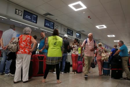 Thomas Cook passengers queue up in a check-in service at Malta International Airport