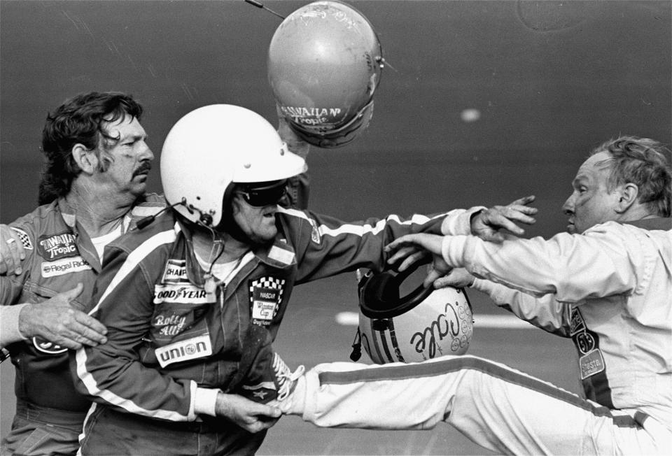 Bobby Allison holds race driver Cale Yarborough's foot after Yarborough kicked him following an argument Feb. 18, 1979 when Yarborough stopped his car during the final lap of the Daytona 500. Allison's brother Donnie was involved in a wreck with Yarborough on the final lap which made brother Bobby stop. (AP Photo/Ric Feld)