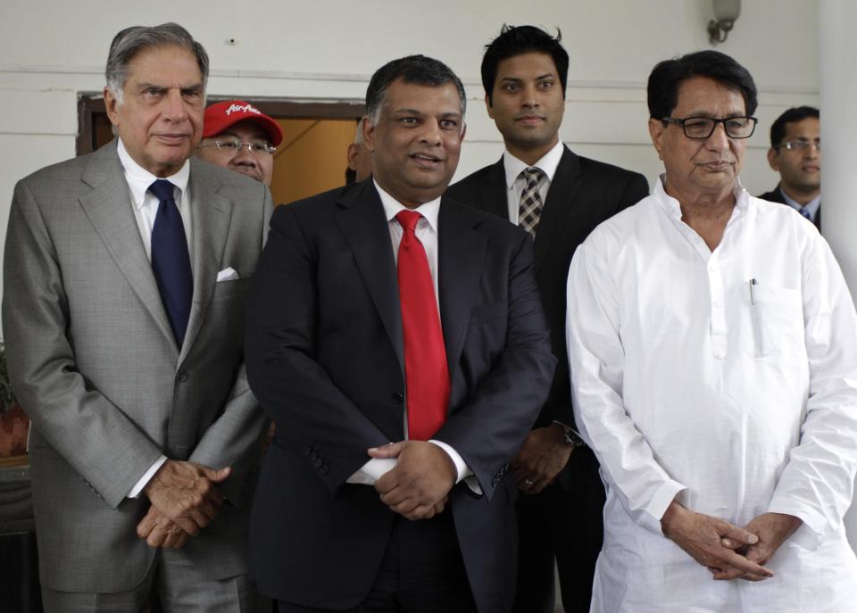 FILE - in this July 2, 2013 file photo, Indian Civil Aviation Minister Ajit Singh, right, Air Asia CEO, Tony Fernandes, center, and Ratan Tata, left, stand at the Arjit Singh's residence after their meeting in New Delhi, India. Malaysia-based Air Asia said it would start a budget carrier with Indian conglomerate Tata Group. India has become a hot ticket for international carriers since opening its airline industry to foreign investors last year. But the potential of a giant market where only a sliver of the population travel by plane also comes with a catch: airlines in India are vastly unprofitable thanks to sky-high costs and cut-throat competition. (AP Photo/Tsering Topgyal, file)