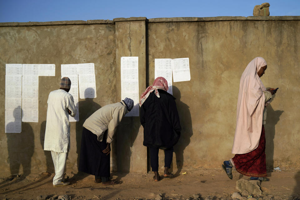 Nigerians check voters' lists at a polling station in Kaduna, Nigeria, Saturday, Feb. 16, 2019. Nigeria's electoral commission delayed the presidential election until Feb. 23, making the announcement a mere five hours before polls were set to open. (AP Photo/Jerome Delay)