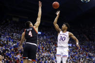 Kansas guard Ochai Agbaji (30) scores a three-point shot over Texas Tech forward Daniel Batcho (4) during the first half of an NCAA college basketball game on Monday, Jan. 24, 2022, in Lawrence, Kan. (AP Photo/Colin E. Braley)