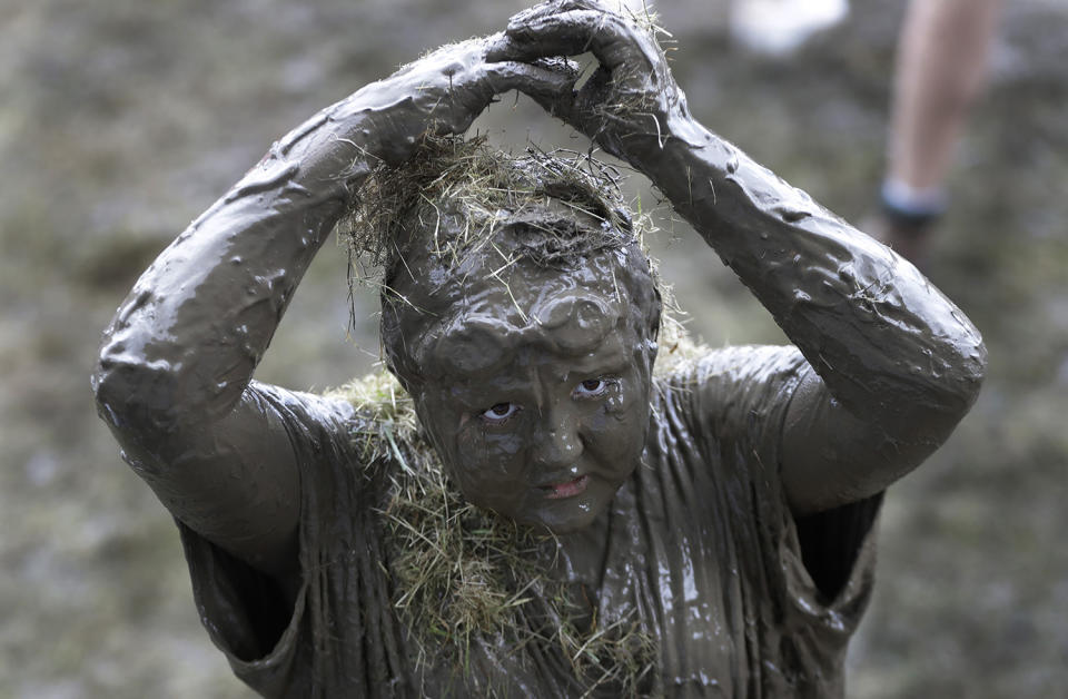 <p>Brian Wilson, 10, adds grass to his mud covered body during Mud Day at the Nankin Mills Park, July 11, 2017 in Westland, Mich. (Photo: Carlos Osorio/AP) </p>