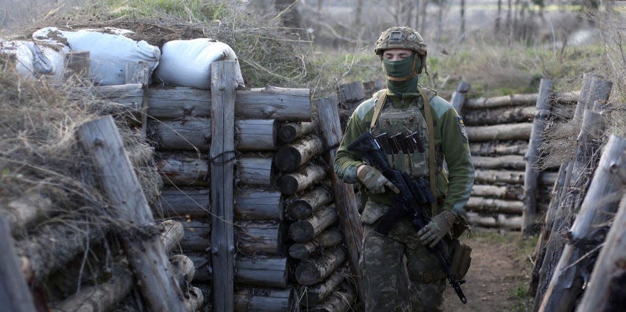 A Ukrainian serviceman patrols along a trench in Schastya, Lugansk region, near the frontline with Russia backed separatists on April 16, 2021