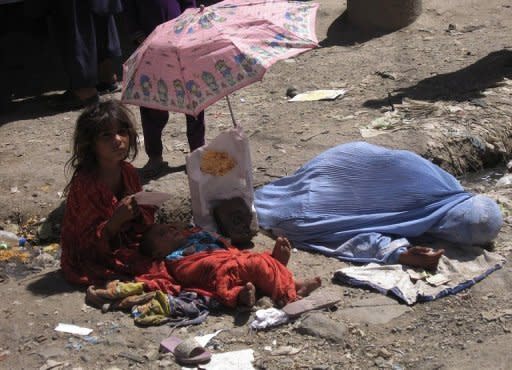 An Afghan woman with her children begs for money on June 13 in Jalalabad, Nankarhar province. Science academies have emphasized the need to help millions rise out of poverty, brake trends of reckless consumption and address population growth