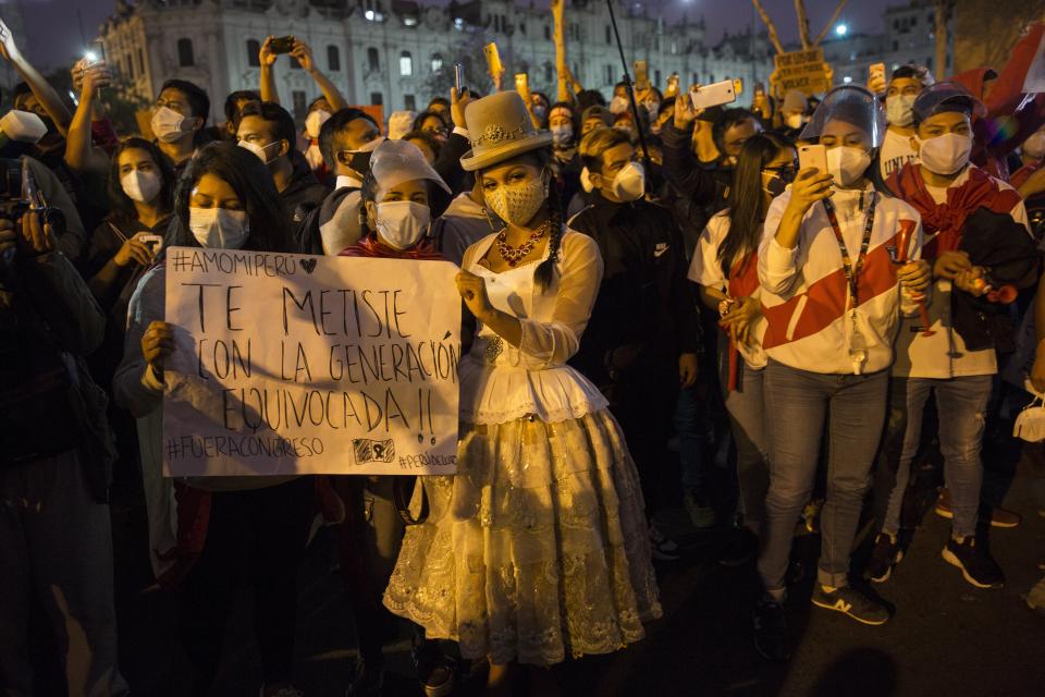 People gather in San Martin square after Peru's new interim President Francisco Sagasti was designated by Congress to lead the nation, in Lima, Peru, Monday, Nov. 16, 2020. Lawmakers chose Sagasti to become the nation's third president in the span of a week after they ousted Martin Vizcarra and the following protests forced his successor Manuel Merino to resign. (AP Photo/Rodrigo Abd)