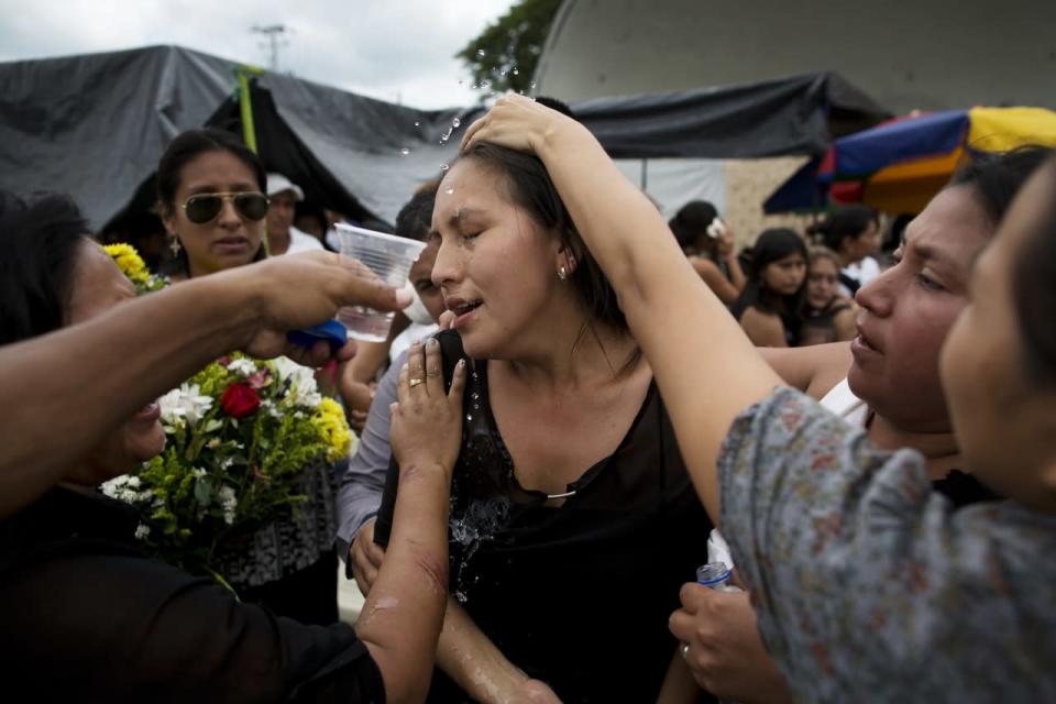 A mourner is revived with water