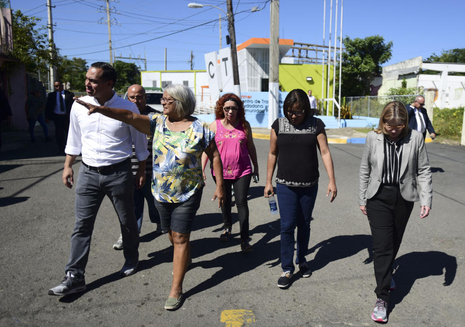 Julian Castro, left, visits Playita, one of the poorest and most affected communities by Hurricane Maria, as San Juan Mayor walks with him, far right, in San Juan, Puerto Rico, Monday, Jan. 14, 2019. The U.S. presidential candidate has joined dozens of high-profile Latinos in Puerto Rico to talk about mobilizing voters ahead of the 2020 elections and increasing Latino political representation to take on President Donald Trump. (AP Photo/Carlos Giusti)