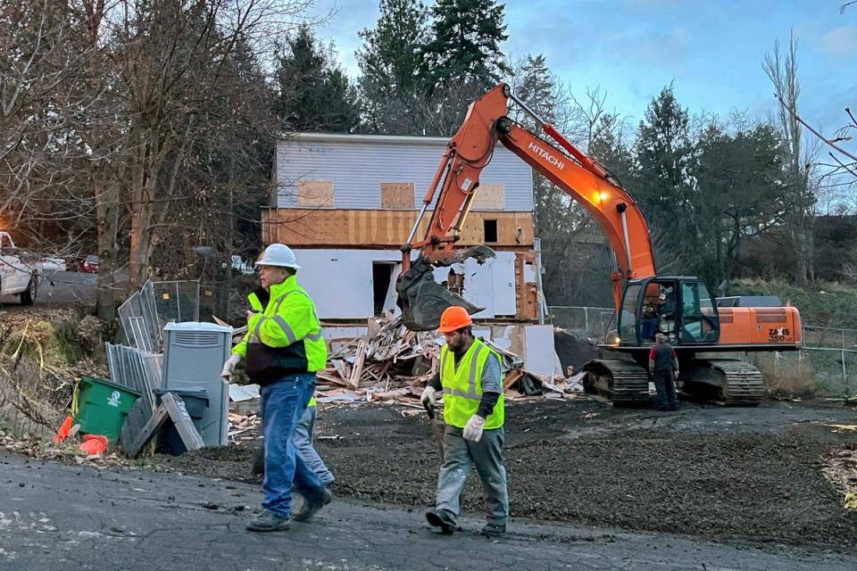 Workers walk past the demolition of the home in Moscow, Idaho, where the four University of Idaho were killed (AP)