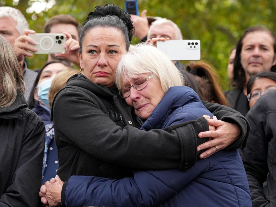 Mourners embrace on The Mall as thousands watched the Queen’s last journey (REUTERS)