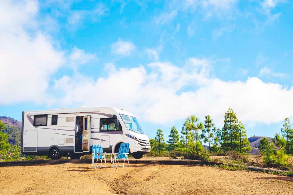 An RV is parked on top of a hill on a nice clear day.