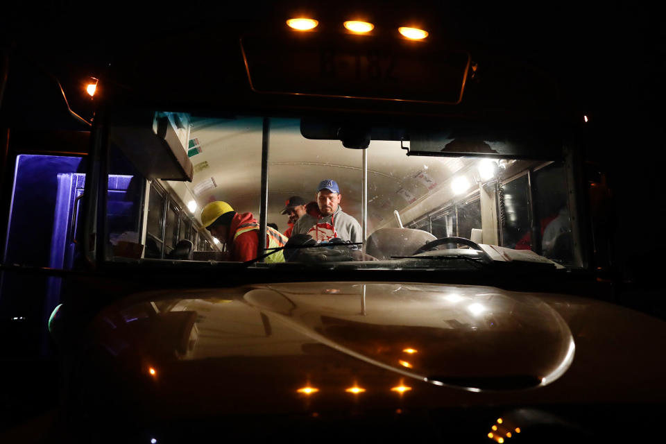 <p>Farmworker Santiago Martinez, of Mexicali, Mexico, right, exits a bus as it arrives at a cabbage field ready for harvest, before dawn outside of Calexico, Calif., March 6, 2018. (Photo: Gregory Bull/AP) </p>