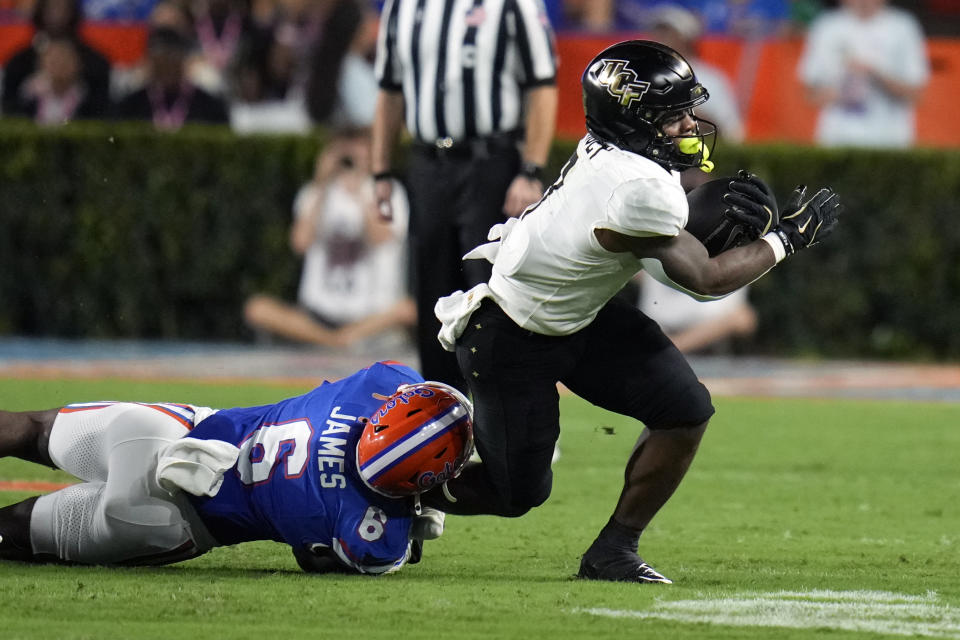 Florida linebacker Shemar James (6) stops Central Florida running back RJ Harvey after a short gain during the first half of an NCAA college football game, Saturday, Oct. 5, 2024, in Gainesville, Fla. (AP Photo/John Raoux)