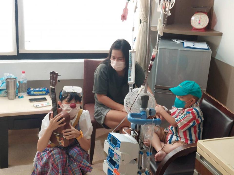 紅鼻子醫生用誇張有趣的動作表情與小病人互動，在旁的家長也沾染歡樂氣氛。 （記者葉進耀攝）