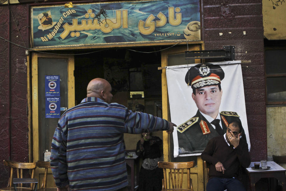 FILE - In this Tuesday, Jan. 27, 2014 file photo, a man sits under a banner with the photo of Defense Minister Gen. Abdel-Fattah el-Sissi as he drinks his tea at the "Al Mosheer Cafe" or "Marshal Cafe" in Cairo, Egypt. The head of Egypt’s military, Abdel-Fattah el-Sissi, is riding on a wave of popular fervor that is almost certain to carry him to election as president. Unknown only two years ago, a broad sector of Egyptians now hail him as the nation’s savior after he ousted the Islamists from power, and the state-backed personality cult around him is so eclipsing, it may be difficult to find a candidate to oppose him if he runs. Still, if he becomes president, he faces the tough job of ruling a deeply divided nation that has already turned against two leaders. (AP Photo/Mohammed Abu Zaid, File)