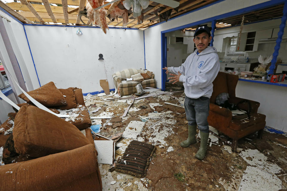Andres Aguilar, a native of Guatemala, says Friday, April 19, 2019, that he and other family members were very scared when they heard the winds of a possible tornado hit their Morton, Miss., home, Thursday afternoon. Augilar said he and his family hid under the house's door frame as much of the roof and ceiling was torn off and the windows were blown out. Strong storms again roared across the South on Thursday, topping trees and leaving a variety of damage in Mississippi, Louisiana and Texas. (AP Photo/Rogelio V. Solis)
