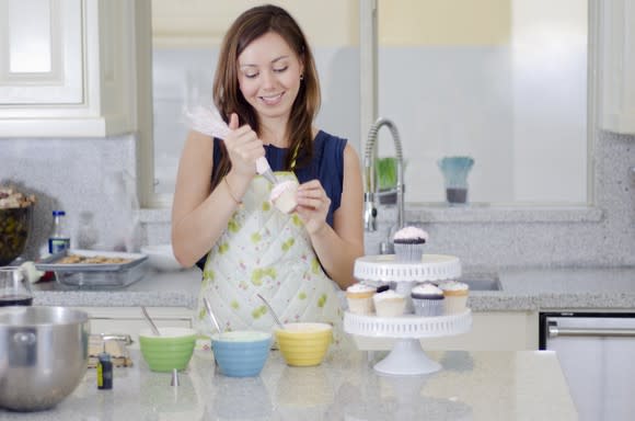 Woman decorating a cupcake