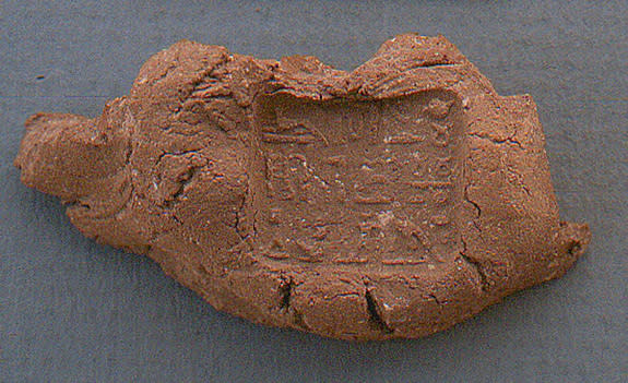 An inscribed seal, used to hold the strings or binding of a papyrus scroll, was found near the fragments of a collar worn by a mummy. The inscription identifies the seal as being for Padihorwer, a man from the town of Qus who worked as an under